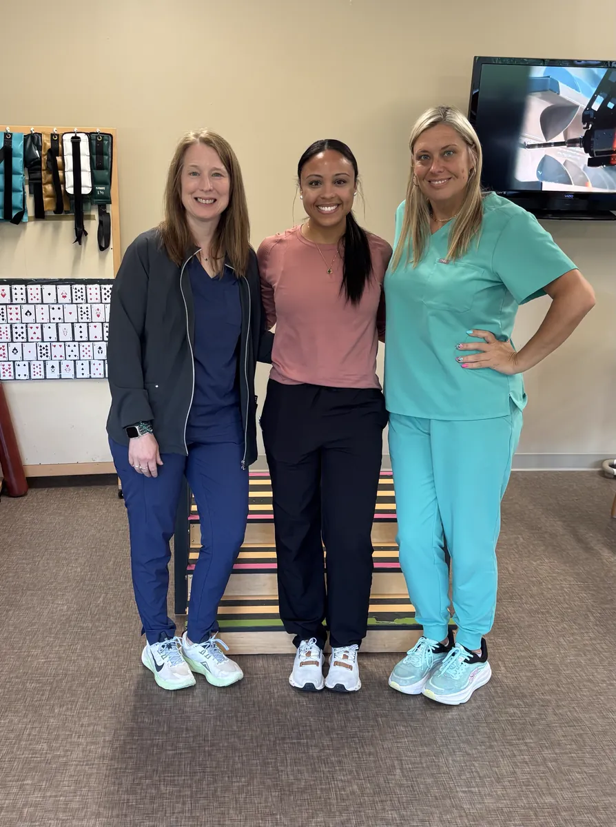 Three Continuum clinicians in a therapy gym