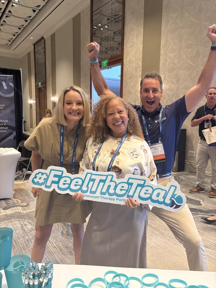 Cheering with the #FeelTheTeal sign at the Continuum booth