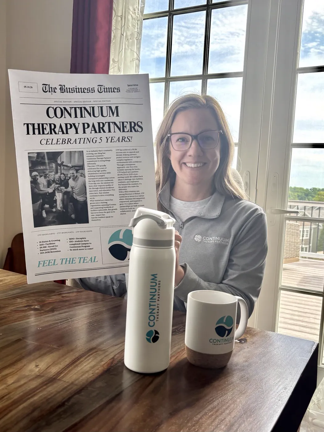 A Continuum team member with the company's five-year anniversary newspaper